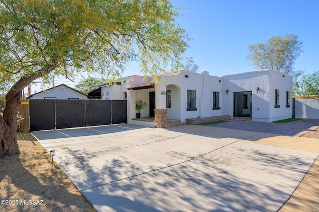 1025 N Perry Ave, Tucson, AZ 85705 - view of front facade featuring fence, stucco siding, and a gate