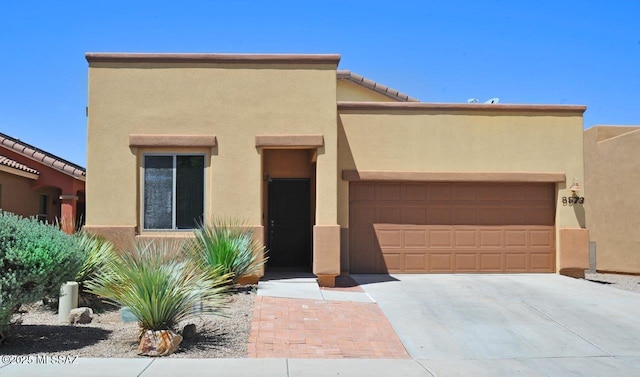 8573 N Western Juniper Ter, Tucson, AZ 85743 - southwest-style home with a garage, driveway, and stucco siding