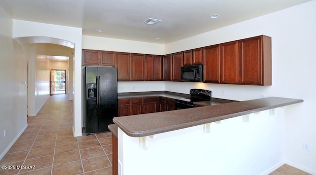 8573 N Western Juniper Ter, Tucson, AZ 85743 - kitchen with light tile patterned flooring, arched walkways, a peninsula, visible vents, and black appliances