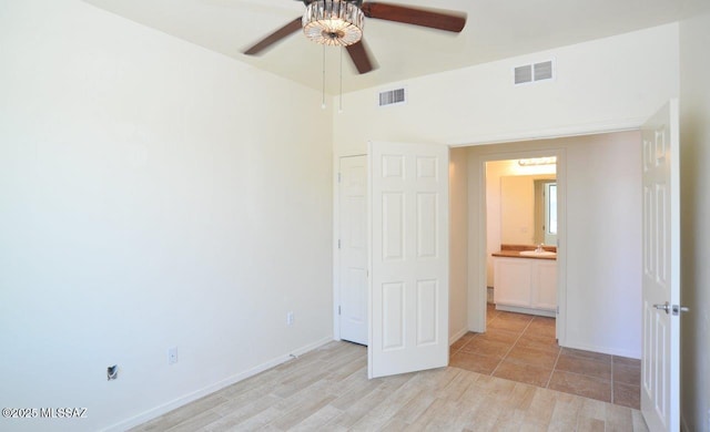 8573 N Western Juniper Ter, Tucson, AZ 85743 - unfurnished bedroom with baseboards, visible vents, a sink, and light wood finished floors