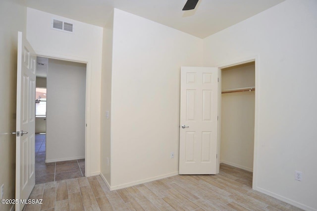 8573 N Western Juniper Ter, Tucson, AZ 85743 - unfurnished bedroom featuring a ceiling fan, baseboards, visible vents, and wood finished floors