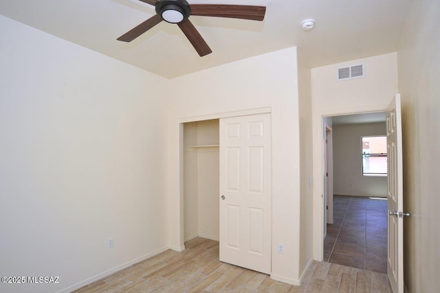 8573 N Western Juniper Ter, Tucson, AZ 85743 - unfurnished bedroom featuring ceiling fan, light wood finished floors, baseboards, visible vents, and a closet