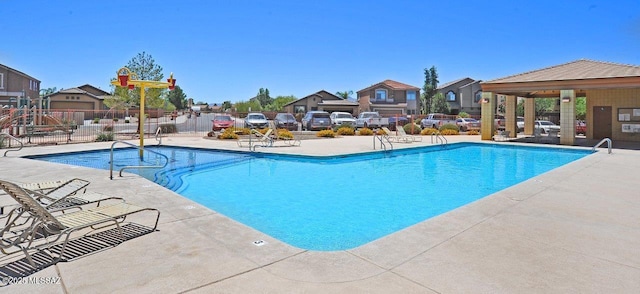 8573 N Western Juniper Ter, Tucson, AZ 85743 - community pool with a patio, fence, and a residential view