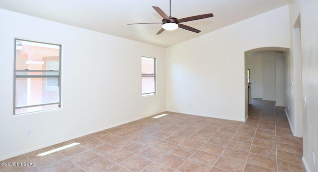 8573 N Western Juniper Ter, Tucson, AZ 85743 - unfurnished room featuring baseboards, arched walkways, ceiling fan, and light tile patterned flooring