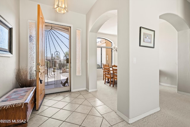 1040 W Stargazer Pl, Oro Valley, AZ 85737 - entryway featuring arched walkways, light colored carpet, a chandelier, and baseboards