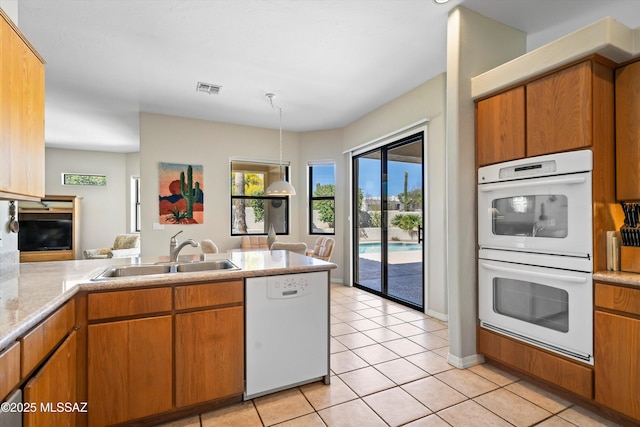 1040 W Stargazer Pl, Oro Valley, AZ 85737 - kitchen featuring white appliances, a sink, a peninsula, light tile patterned flooring, and light countertops