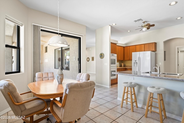 1040 W Stargazer Pl, Oro Valley, AZ 85737 - dining area featuring ceiling fan, light tile patterned flooring, baseboards, arched walkways, and recessed lighting