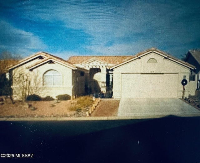 ranch-style house with an attached garage and aphalt driveway