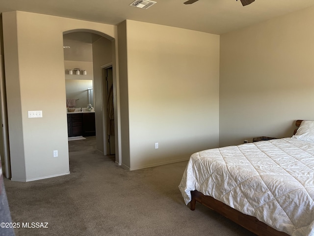 carpeted bedroom with arched walkways, baseboards, and visible vents