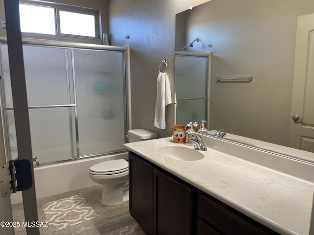 bathroom featuring vanity, toilet, and shower / bath combination with glass door