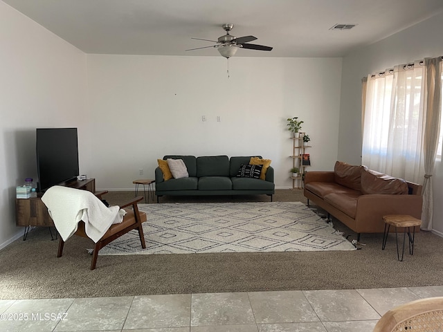 living room with visible vents, baseboards, and ceiling fan