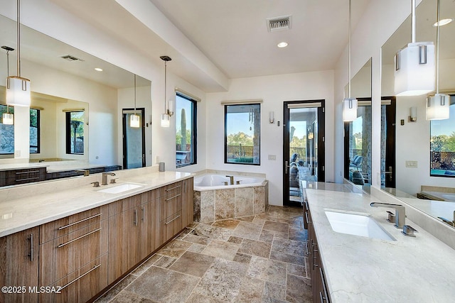 bathroom with a healthy amount of sunlight, a garden tub, and a sink