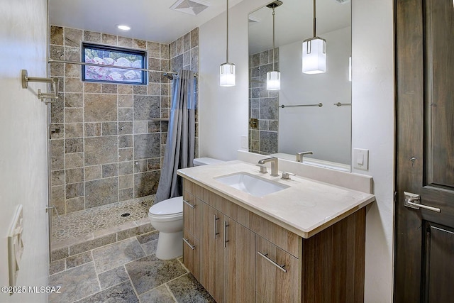 full bath with tiled shower, vanity, toilet, visible vents, and stone finish floor
