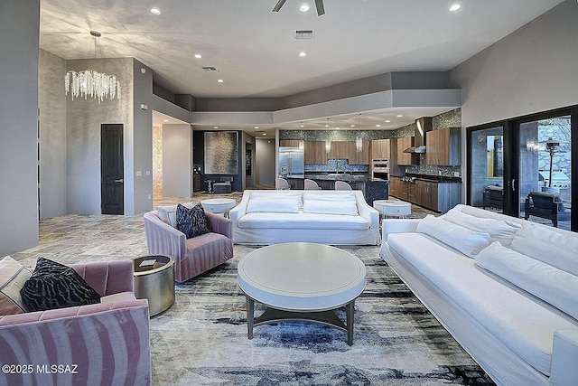 living room featuring visible vents, recessed lighting, and ceiling fan with notable chandelier