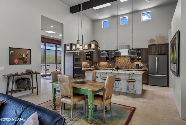 dining room with recessed lighting, a high ceiling, and light speckled floor