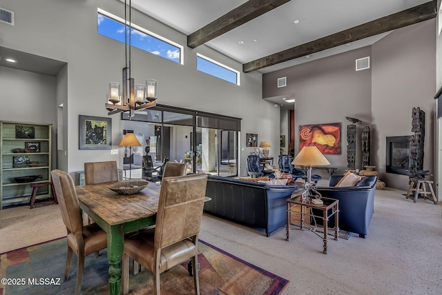 dining room featuring visible vents, a notable chandelier, beam ceiling, and a towering ceiling