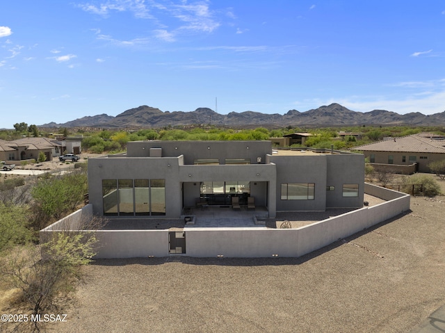 back of property with a patio, a fenced backyard, a mountain view, and stucco siding