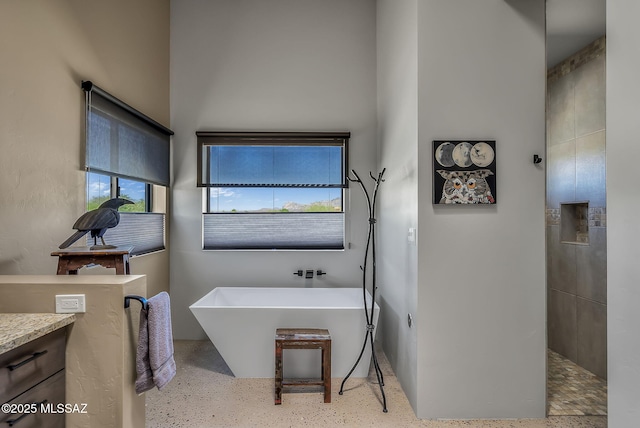 bathroom with vanity and a soaking tub