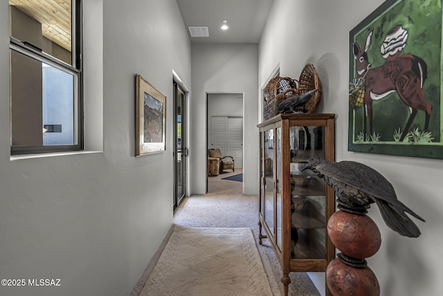 corridor featuring baseboards and carpet