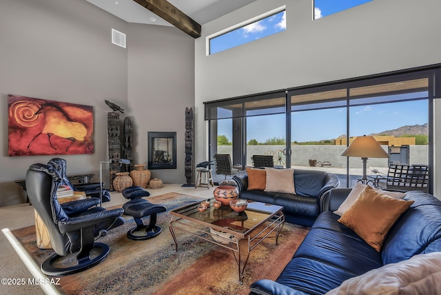 living area with visible vents, beamed ceiling, and a towering ceiling