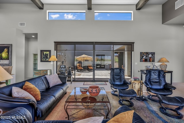 living room with visible vents, a towering ceiling, and beamed ceiling