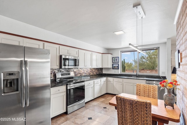 5920 N Campbell Ave, Tucson, AZ 85718 - kitchen featuring stainless steel appliances, a sink, decorative backsplash, dark countertops, and white cabinets