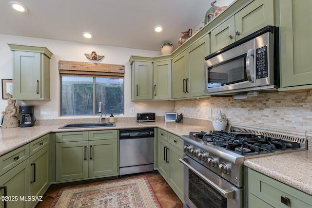 kitchen featuring a sink, appliances with stainless steel finishes, green cabinetry, and light countertops