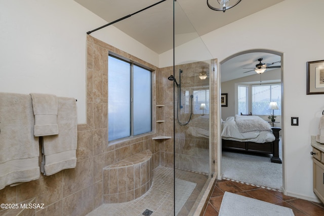full bathroom featuring vanity, tile patterned flooring, ensuite bathroom, tiled shower, and a ceiling fan