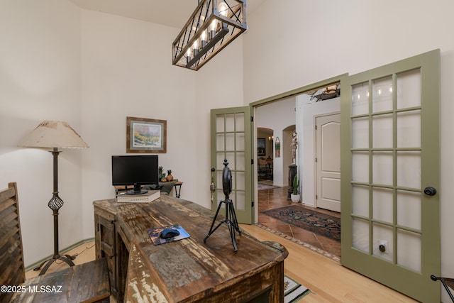 home office featuring arched walkways and a high ceiling