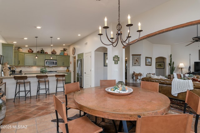 dining area with arched walkways, recessed lighting, ceiling fan with notable chandelier, and visible vents