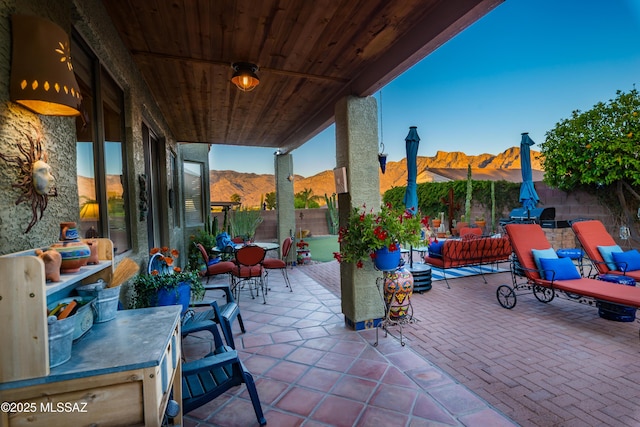 view of patio featuring a mountain view, outdoor dining area, and a fenced backyard