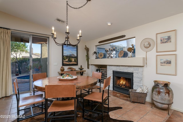 dining room featuring visible vents, an inviting chandelier, and a fireplace