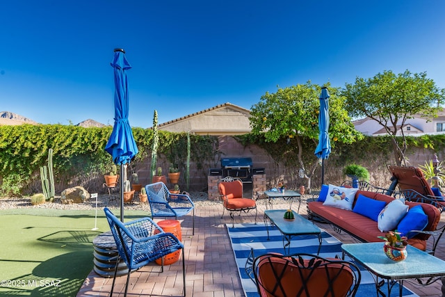 view of patio / terrace featuring area for grilling, fence, outdoor lounge area, and a grill
