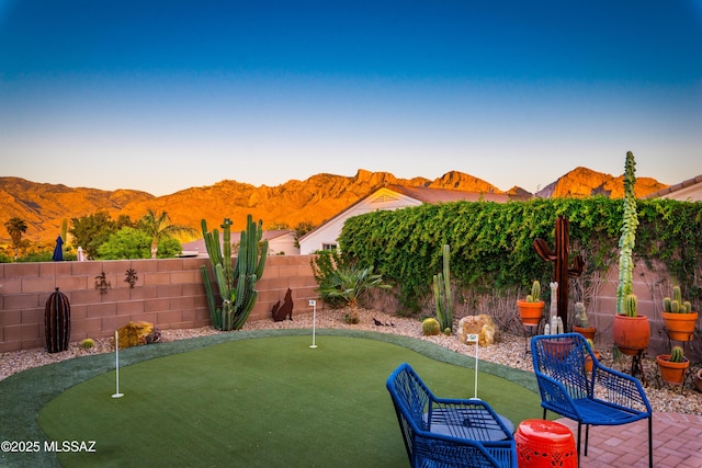 view of yard with a fenced backyard and a mountain view