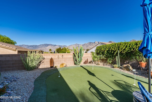 view of yard with a fenced backyard and a mountain view