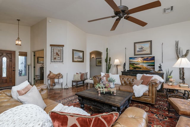 living area featuring visible vents, arched walkways, ceiling fan, and tile patterned floors