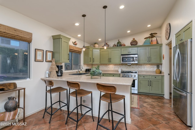 kitchen with a sink, a kitchen breakfast bar, stainless steel appliances, a peninsula, and green cabinets