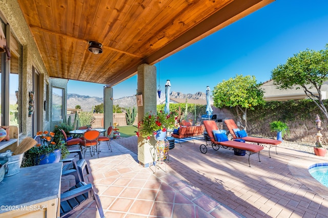 view of patio / terrace featuring a fenced backyard, a mountain view, and outdoor dining area