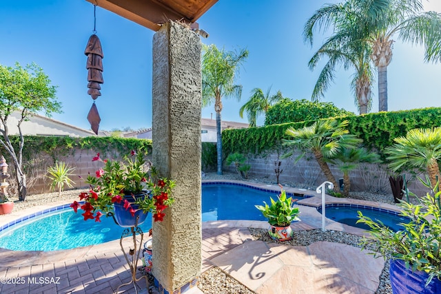 view of pool featuring a fenced backyard, a fenced in pool, and an in ground hot tub