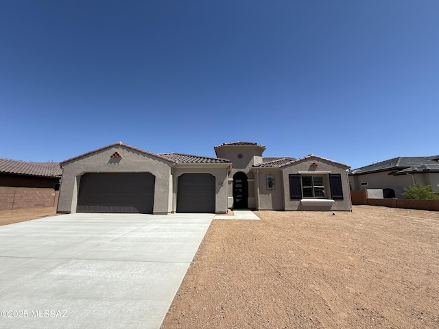 66414 E Peregrine Pl, Tucson, AZ 85739 - mediterranean / spanish-style home featuring an attached garage, stucco siding, concrete driveway, and a tiled roof