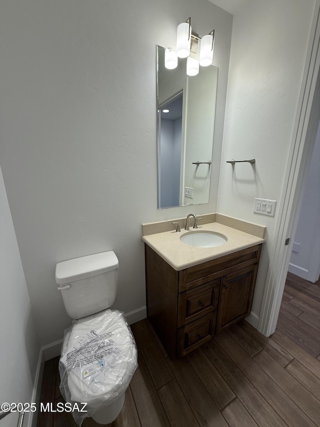 66414 E Peregrine Pl, Tucson, AZ 85739 - bathroom featuring vanity, wood finished floors, toilet, and baseboards
