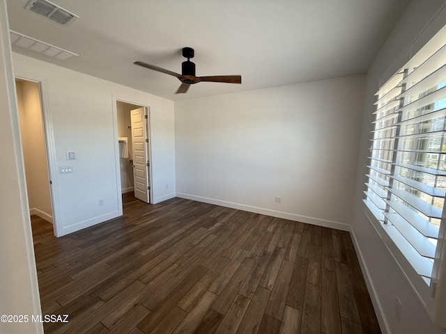 66414 E Peregrine Pl, Tucson, AZ 85739 - unfurnished bedroom with dark wood-style floors, a walk in closet, baseboards, and a closet