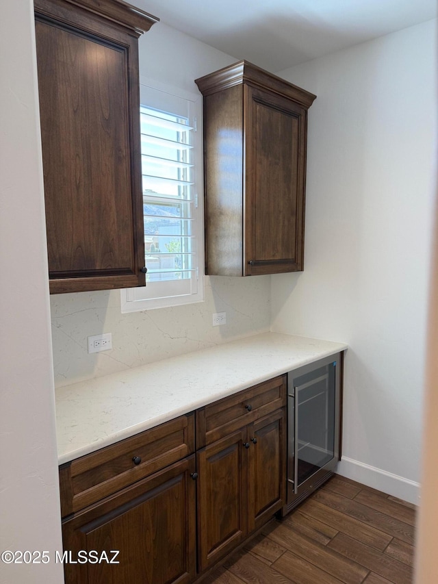 66414 E Peregrine Pl, Tucson, AZ 85739 - kitchen featuring wine cooler, dark wood-style flooring, light countertops, baseboards, and dark brown cabinets