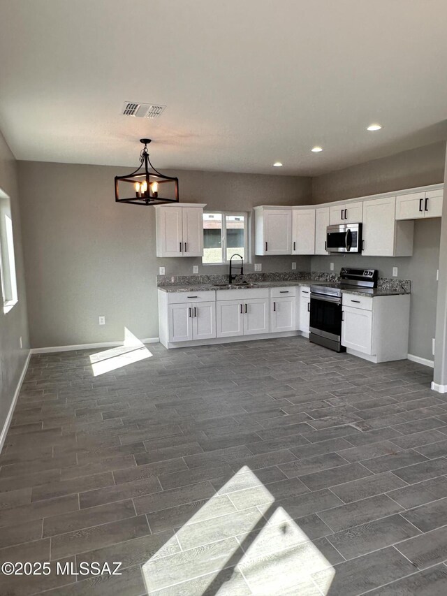 328 E 24th St, Tucson, AZ 85713 - kitchen with stainless steel appliances, recessed lighting, white cabinets, and baseboards