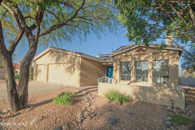 view of front facade featuring an attached garage, stucco siding, and concrete driveway