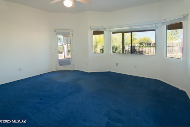 unfurnished room featuring baseboards, ceiling fan, and dark colored carpet