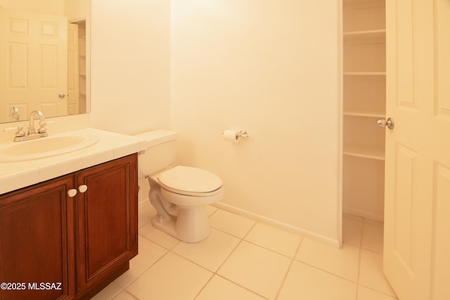 bathroom with toilet, baseboards, tile patterned flooring, and vanity