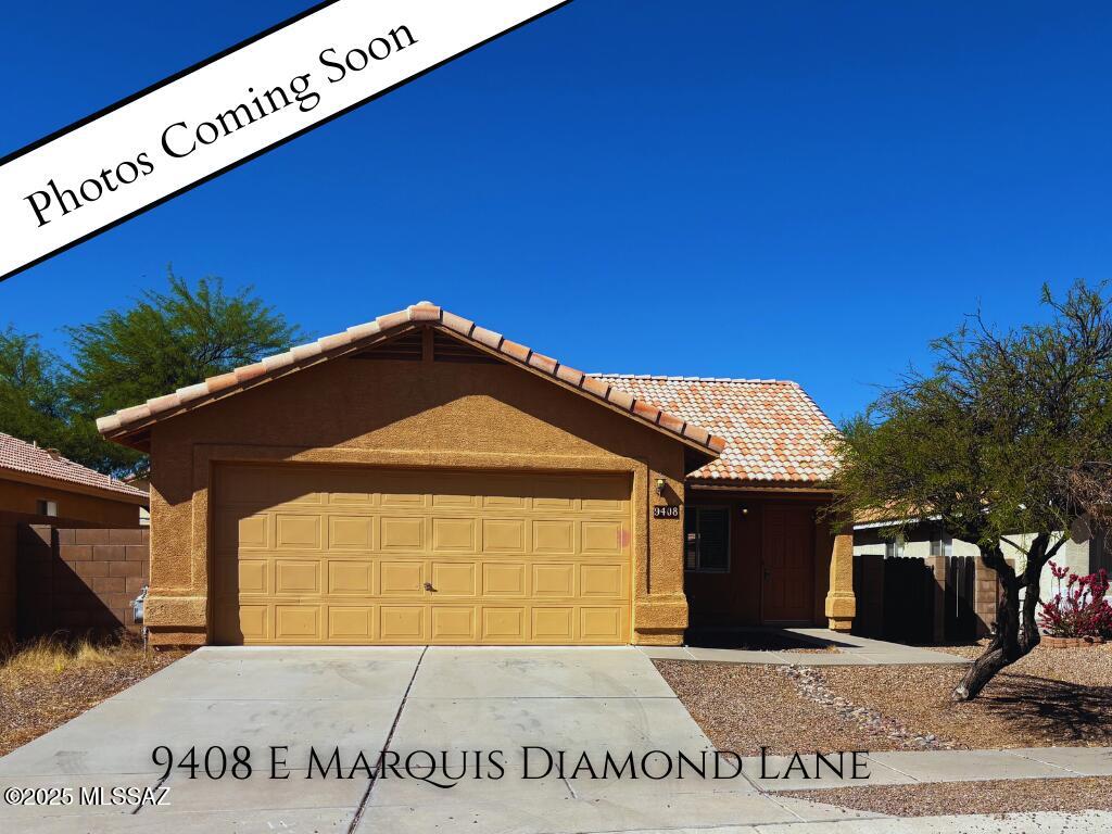 single story home with stucco siding, fence, a tiled roof, and an attached garage