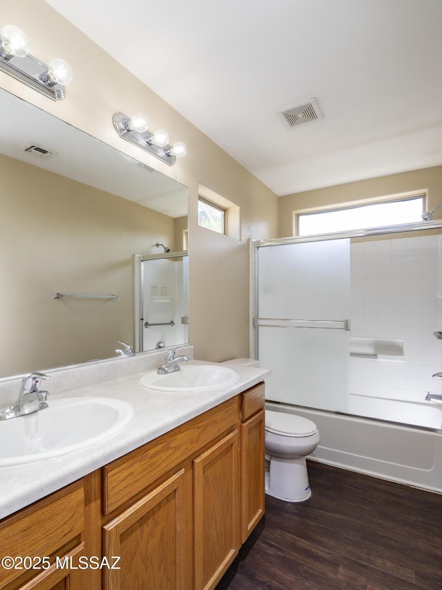 4249 E Cholla Desert Trl, Tucson, AZ 85706 - bathroom with double vanity, toilet, wood finished floors, and enclosed tub / shower combo