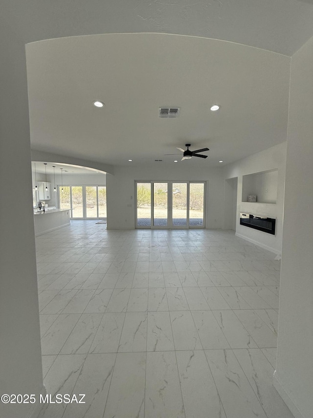 unfurnished living room with visible vents, ceiling fan, recessed lighting, and marble finish floor